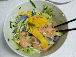 15、不用洗面的～五颜六色的凉皮,放入碗里，加入切好的黄瓜丝，根据个人口味加入上述调料，搅拌均匀。