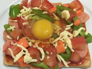 5、微波炉吐司披萨,如图用勺子在吐司中间压一个坑，打入鸡蛋，这样可以避免蛋液流失