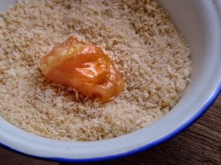 4、快手免炸的 酥脆辣子鸡,将鸡肉放入面包糠内滚一圈