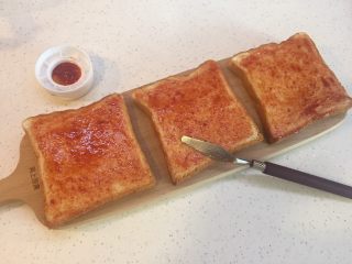 4、懒人菜谱快手早餐～面包火腿芝士披萨????,用小抹刀或者勺子背面抹均匀