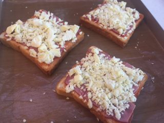 10、懒人菜谱快手早餐～面包火腿芝士披萨????,撒上马苏里拉奶酪碎，尽量均匀，注意边上也撒满，否则容易糊