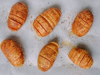 2、风琴土豆,在烤盘还有土豆身体以及薄片间刷橄榄油,确保每一层之间都有油,撒上椒盐跟胡椒粉调味。