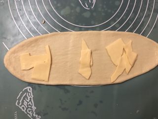 8、葱香芝士面包,擀成长舌状，放入撕碎的芝士