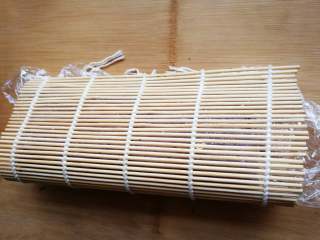 10、翻转花朵寿司,寿司卷帘对折,压实卷帘两端,中间不要用力压。