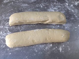 7、香酥油条,面板上撒上面粉，把饧好的面团放上，并一分为二
