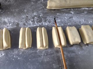 10、香酥油条,再把俩小条面对面的叠在一起，用筷子在中间用力压下，油条坯子便做好了