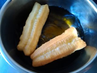 12、香酥油条,把油条坯子稍微拉长后，放入油锅（轻点放，小心别烫着手），转中小火炸制，油条浮起后，用筷子快速翻转，使其能受热均匀迅速膨胀