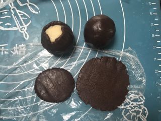 6、广式巧克力莲蓉月饼,取一个面团用手掌摁一下擀成圆形，包上莲蓉馅，用虎口慢慢收口