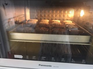 11、广式巧克力莲蓉月饼,烤箱预热200度预热好，月饼表面喷水，要用喷雾器，不能直接朝着月饼喷，要喷在月饼上空让水雾慢慢掉下，然后放入烤箱200度6分钟后取出刷蛋液