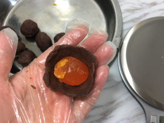 5、蛋黄酥（黄油+玉米油版）,醒面时间包蛋黄馅，取适量豆沙按成圆形，放入半个咸鸭蛋黄。