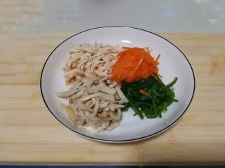 9、胡萝卜拌鸡丝,把鸡肉丝、胡萝卜丝、青椒丝、杏鲍菇丝装入盘子