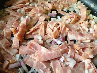 5、彩蔬培根牛肉粒披萨,平底锅无水无油,放入洋葱碎和培根片,中火炒至洋葱变透明,培根变色出油,盛出