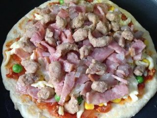 12、彩蔬培根牛肉粒披萨,放上牛肉粒和炒好的培根,再撒上马苏里拉奶酪,胡萝卜花片,最后撒上黑胡椒碎