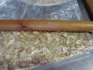 4、雪花酥,熟花生米用保鲜袋装着擀压成碎粒