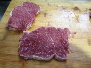 1、秘制烤牛肉披萨,牛里脊洗净切片，用刀背拍松，切小块
