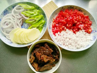 7、秘制烤牛肉披萨,发面的时间将半个洋葱切圈，剩下半个切细碎小粒，西红拌切小粒，土豆切片，青椒斜切成片