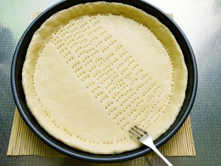 15、秘制烤牛肉披萨,推至中间薄边缘厚，做好的披萨饼用小叉子均匀扎出小洞