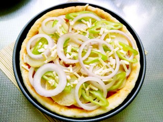 18、秘制烤牛肉披萨,码上土豆片、青椒片和洋葱圈，撒上一层马苏里拉奶酪，继续放烤箱烤8分钟