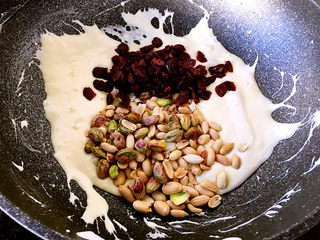 8、雪花酥,关火，加入蔓越莓干、杏仁、花生和开心果，迅速翻拌几下。
