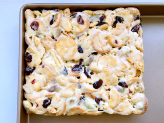 13、雪花酥,带上一次性手套慢慢推压紧实雪花酥团，然后进一步借用塑料刮板整形成方形。