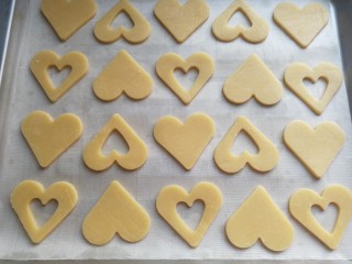 8、爱心果酱夹心饼干,刻出所有饼干胚摆入烤盘，然后放入预热好的烤箱中层上下火170度烤约20分钟即可