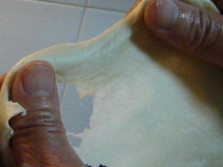 3、意大利披萨饼,使面揉出筋来然后加油继续揉，使面筋力十足能像口香糖一样用双手拉出薄膜来便完成了第一道工序。