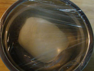 5、意大利披萨饼,把面盆上面罩上保鲜膜放在屉上盖好锅盖进行发酵。