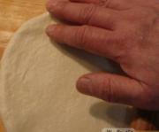 7、意大利披萨饼,然后手上抹些油开始再次揉面，稍把面团放气揉成圆形，然后用擀面棍擀成比模具稍大就OK，专业的厨师人家是用手抛出来的面饼，这需要一些技巧，咱们干不来只能用擀面杖擀了，呵呵！很容易的。