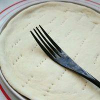 9、黑椒鸡肉披萨,放进披萨盘,整形。用手按压披萨饼边,使其服帖