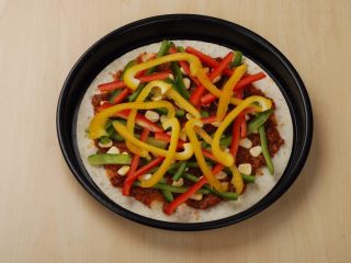 4、意大利肉酱缤纷薄脆披萨,青红黄椒洗净切丝后摆在食材上