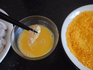 7、黑椒鸡米花,取一块鸡胸肉放入蛋液内粘匀