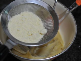 3、玫瑰花杏仁曲奇饼,白豆沙加入一个蛋黄，拌匀，筛入杏仁粉，拌至无颗粒状