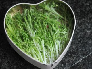 11、玫瑰花杏仁曲奇饼,等待冷却的时候，我们可以整理装饰盒了，在心形的盒子里摆上些碧绿的青菜（青菜随意选择，注意选择叶片比较小的，零碎点的看起来更漂亮。）