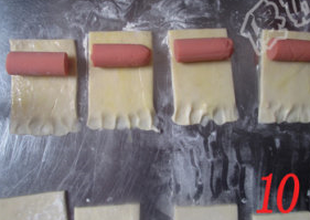 10、酥皮香肠卷,面皮长其中一头边缘用手压扁，刷上蛋液，在没有压扁那头放上一截香肠。