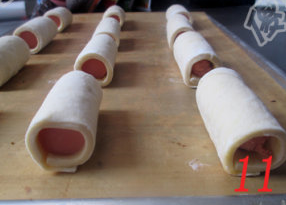 11、酥皮香肠卷,从没有扁的那头开始卷起成卷状，排入烤盘。