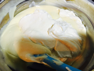 13、提拉米苏,把打好的淡奶油倒入蛋黄糊里翻拌均匀。