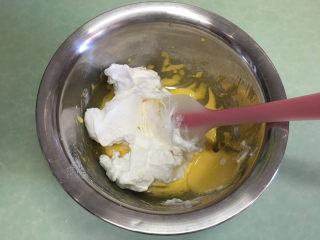 6、手指饼干,取一半蛋白霜倒入蛋黄糊中。