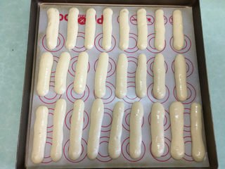 13、手指饼干,裱花袋顶部剪开，在烤盘中挤成长短相同的条状。