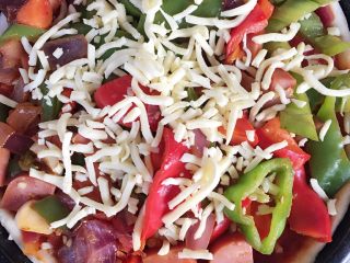 5、自制披萨,如图，放入小炒，再放一层马苏里拉芝士，放入烤箱200度，23分钟上下烤