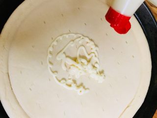 3、日式鳗鱼披萨,将蛋黄酱挤在披萨饼底上