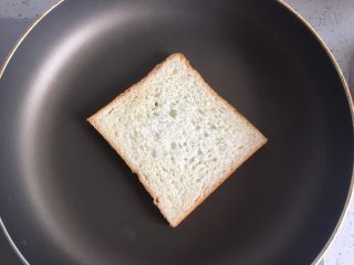 1、火腿三明治,面包片放入平底锅中煎至两面稍微金黄