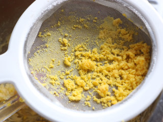 3、可可玛格丽特饼干,熟蛋黄碾碎，过筛，制成蛋黄细末，加入打发好的黄油中。