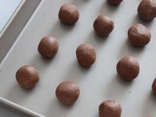 6、可可玛格丽特饼干,取出冷藏好的面团，将面团分成大小均匀的小面团，每个大约8g。揉圆、捏紧，放入烤盘中。