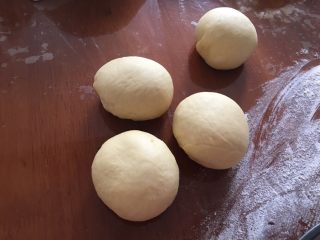 4、蓝莓夹心网纹面包,发酵结束后拿出来排气,分出一个90克左右的面团,做网纹部分,其他的分成三份,滚圆盖保鲜膜松醒10分钟备用