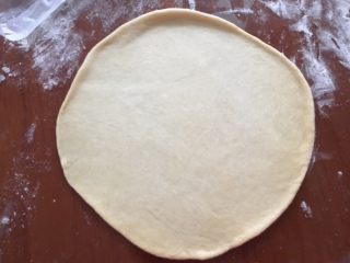 6、蓝莓夹心网纹面包,取一个面团擀成圆片,大小和八寸披萨模底一样大,一定要擀的时候超过这个尺寸才行,因为放到模具里的时候会回缩,总之放进去的时候和模具一样大小就行