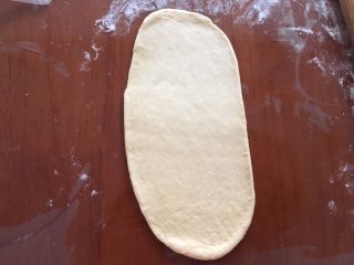 9、蓝莓夹心网纹面包,把网纹面团擀成椭圆形,长度略微超过模具的直径,宽度不要超过自己的网纹刀的宽度