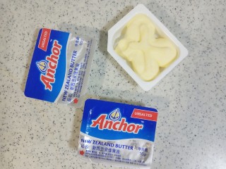 3、镜面芒果慕斯蛋糕,将黄油倒入碗中，隔水融化