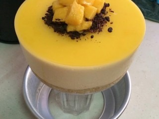 16、镜面芒果慕斯蛋糕,在模具一周用吹风机开热风吹一下，放个杯子在模具底部顶一下，即可脱膜