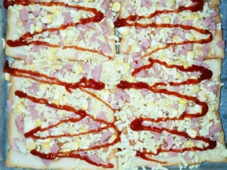 7、吐司披萨,再洒一层奶酪碎，挤上番茄酱，入烤箱烤170度15分钟即可，时间可依各家烤箱为准