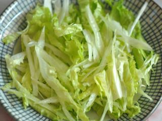 4、黑醋金枪鱼沙拉,将生菜丝铺在盘底。